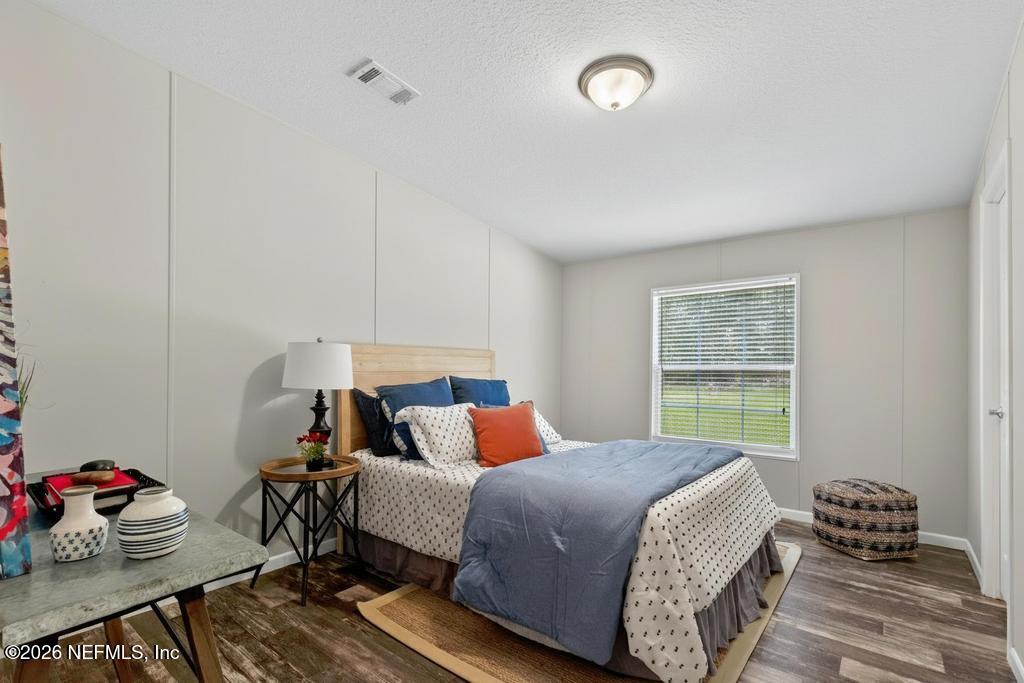 85146 Eady Lane Yulee, FL 32097 - Photo 37 of 74 a bedroom with a bed and wooden floor