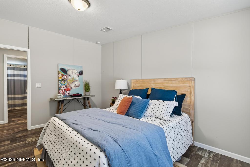 85146 Eady Lane Yulee, FL 32097 - Photo 38 of 74 a bedroom with a bed and wooden floor