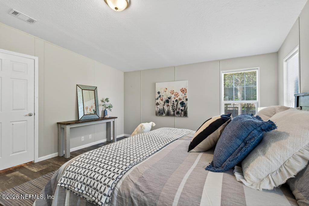 85146 Eady Lane Yulee, FL 32097 - Photo 42 of 74 a bedroom with a bed and a dresser with rug