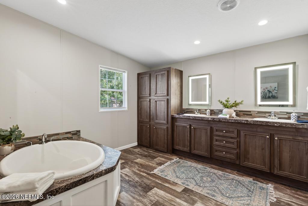 85146 Eady Lane Yulee, FL 32097 - Photo 45 of 74 a spacious bathroom with a granite countertop sink and a bathtub