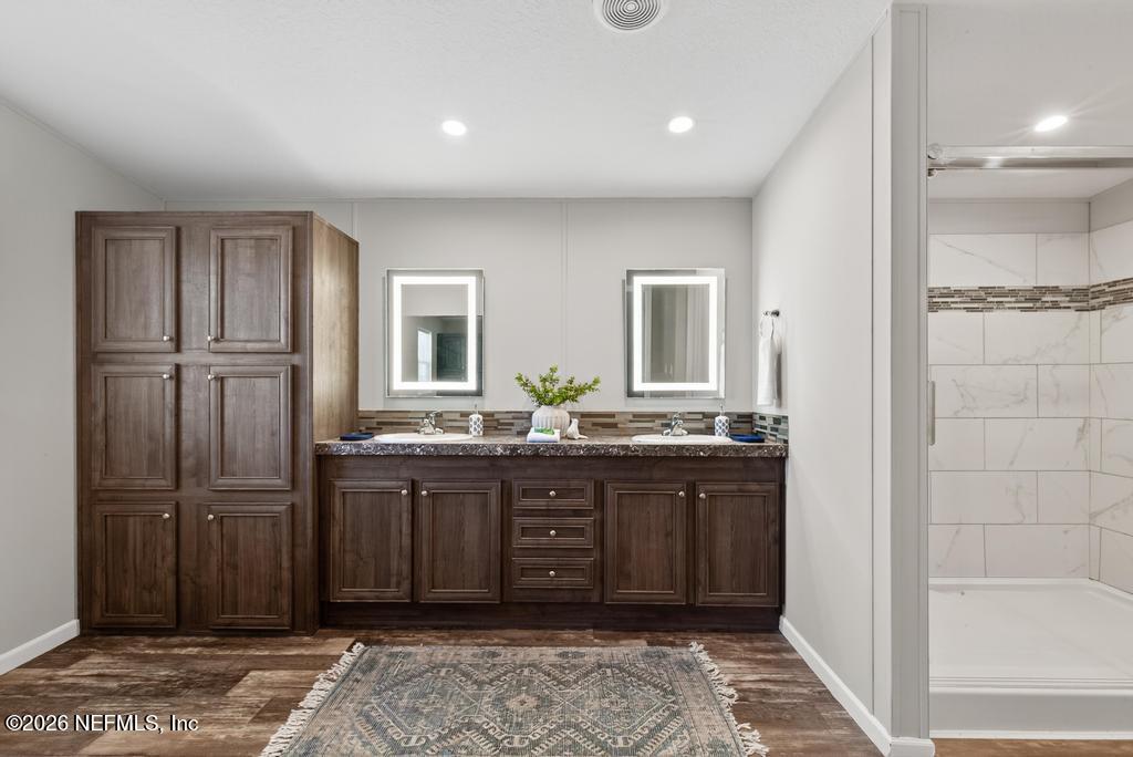 85146 Eady Lane Yulee, FL 32097 - Photo 46 of 74 a bathroom with a granite countertop sink and a mirror
