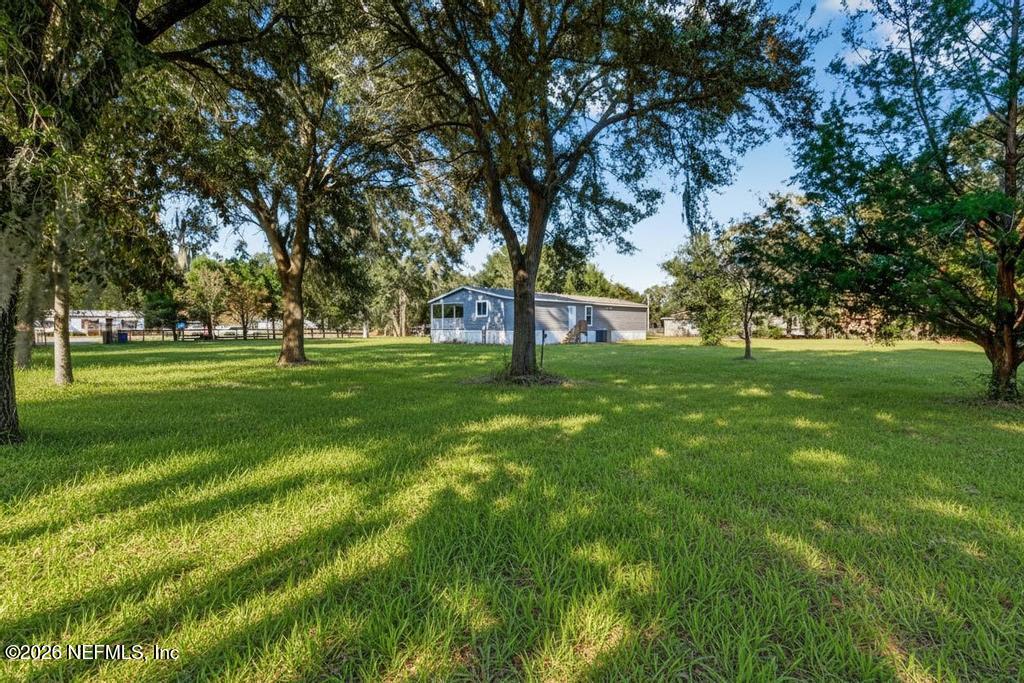 85146 Eady Lane Yulee, FL 32097 - Photo 55 of 74 a view of grassy field with benches and trees all around