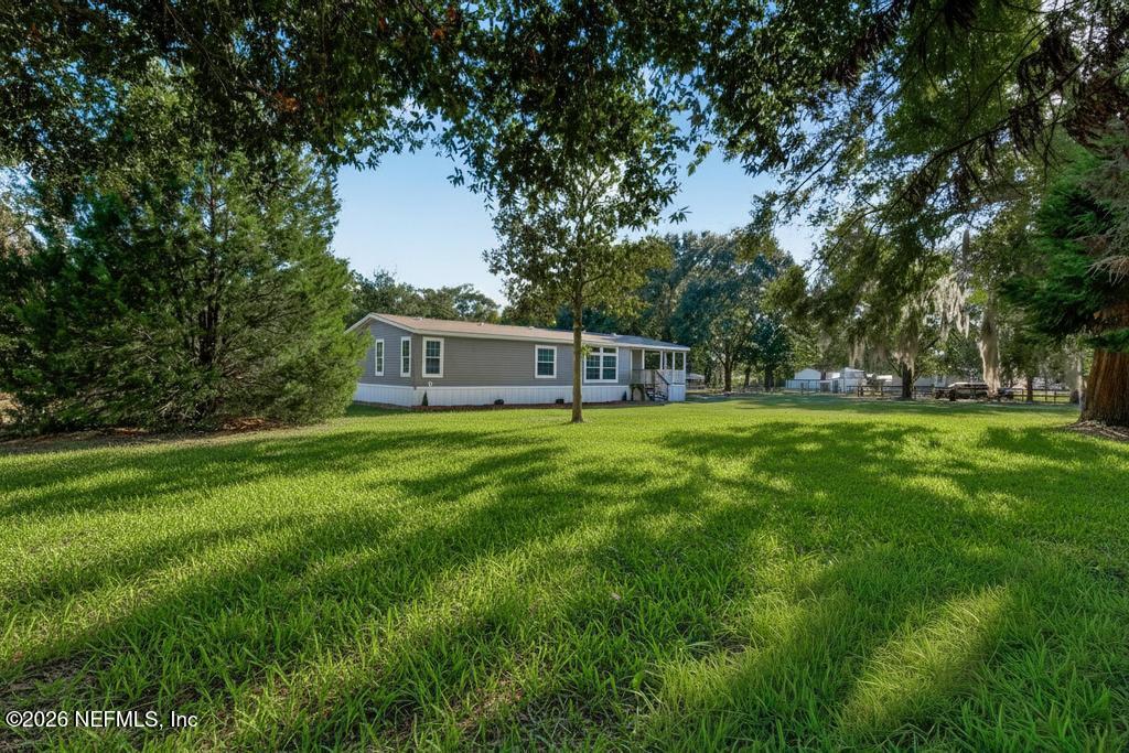 85146 Eady Lane Yulee, FL 32097 - Photo 6 of 74 a view of a house with backyard and a tree
