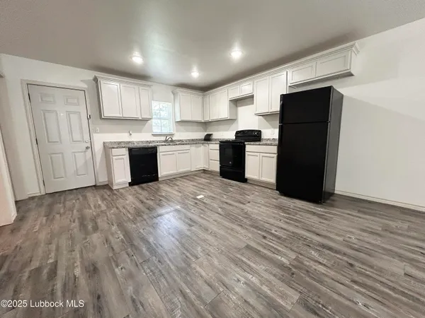 a large kitchen with stainless steel appliances granite countertop a refrigerator and a sink