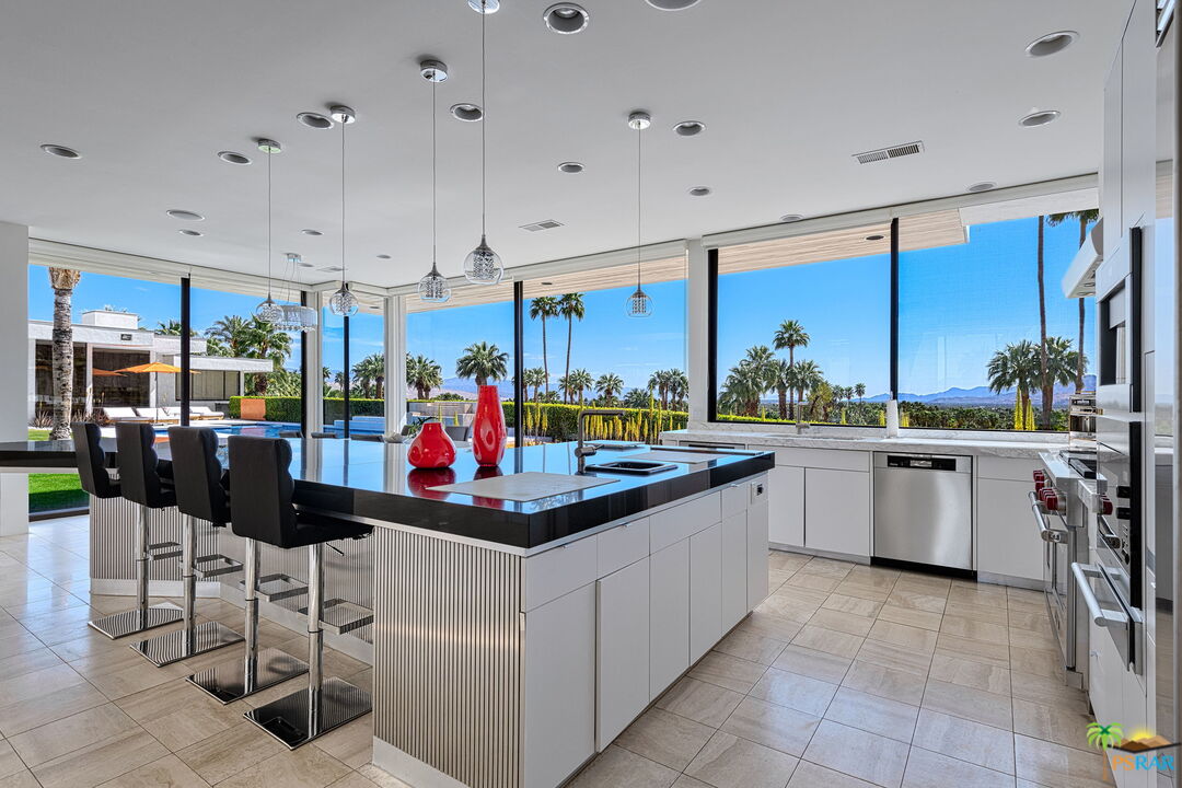 700 West Stevens Road Palm Springs, CA 92262 - Photo 22 of 54 a kitchen with stainless steel appliances kitchen island granite countertop a table and chairs