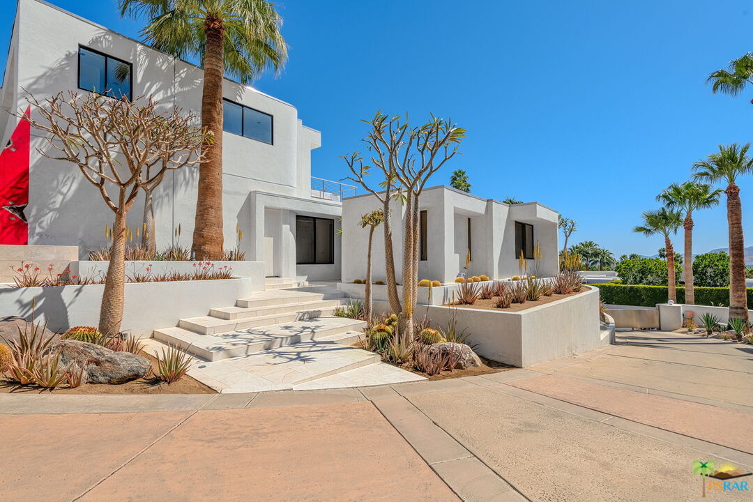 700 West Stevens Road Palm Springs, CA 92262 - Photo 4 of 54 a view of a white house with a large tree and a yard