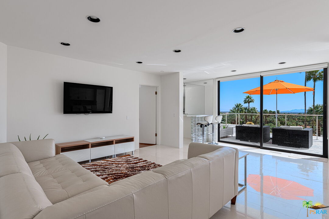 700 West Stevens Road Palm Springs, CA 92262 - Photo 42 of 54 a living room with furniture a flat screen tv and a floor to ceiling window