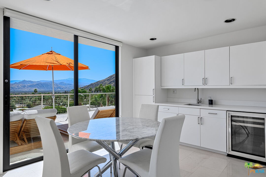 700 West Stevens Road Palm Springs, CA 92262 - Photo 44 of 54 a view of a kitchen with a dining table chairs and a kitchen