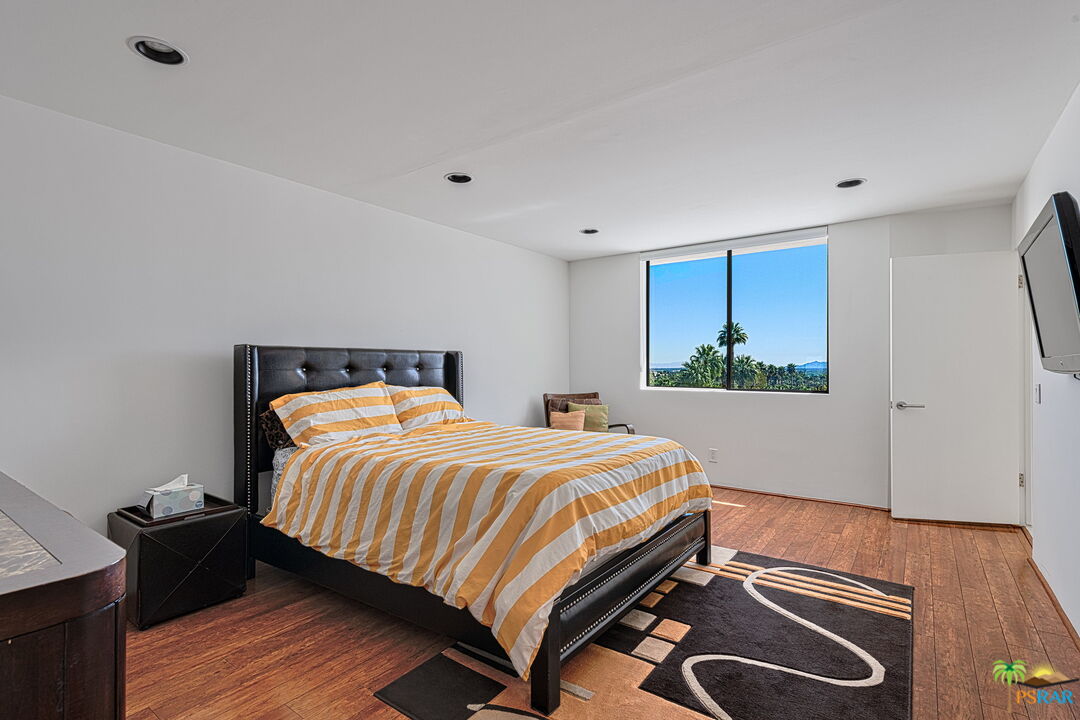 700 West Stevens Road Palm Springs, CA 92262 - Photo 45 of 54 a bedroom with a bed and wooden floor