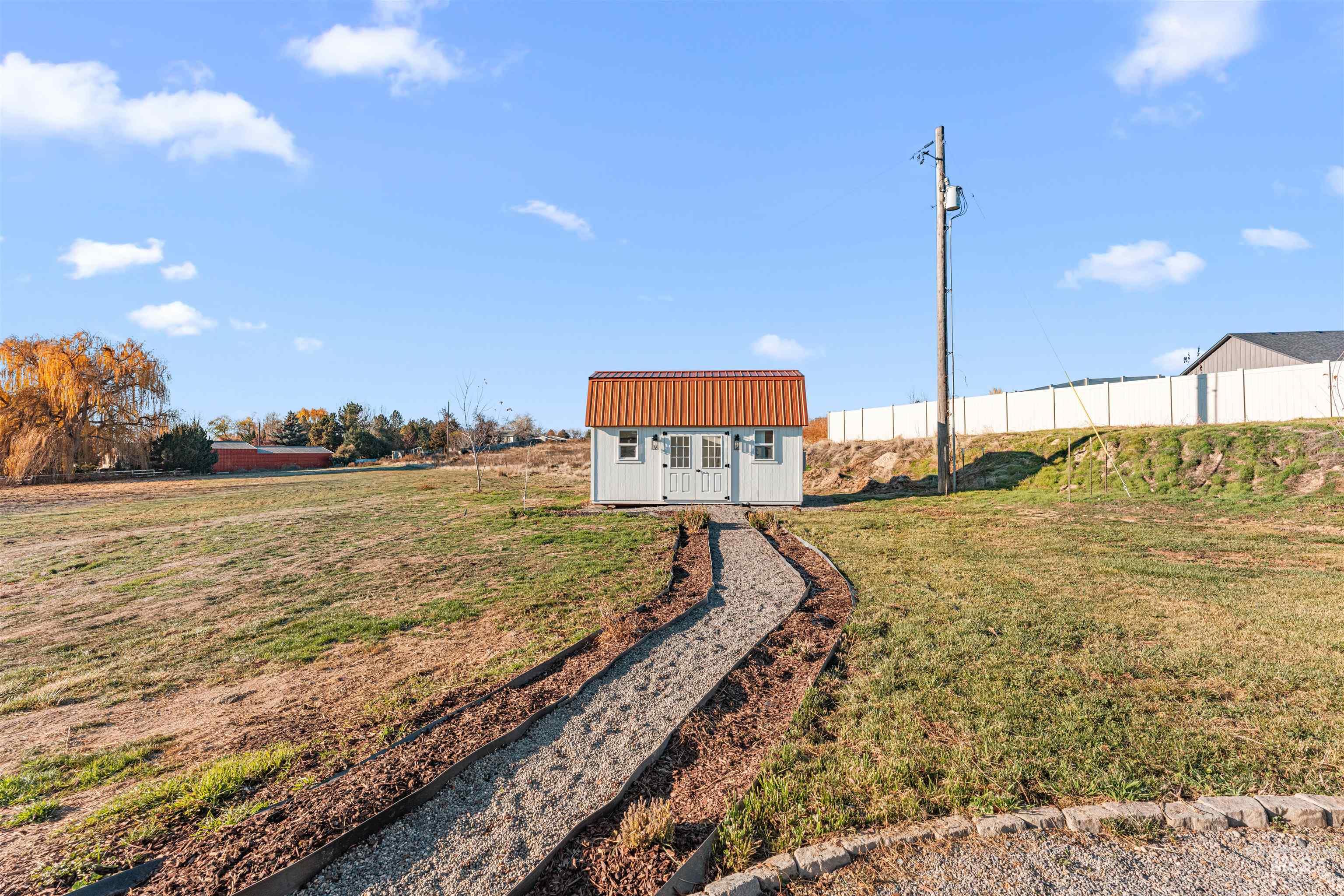 24141 Wanda Way Middleton, ID 83644 - Photo 13 of 20 Exterior space featuring a yard, a metal roof, and a storage unit