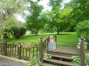 9790 Wilson Mills Road Chardon, OH 44024 - Photo 29 of 33 More lush landscaping and huge deck on back of entire home with sliders from family room and the kitchen making for great entertaining