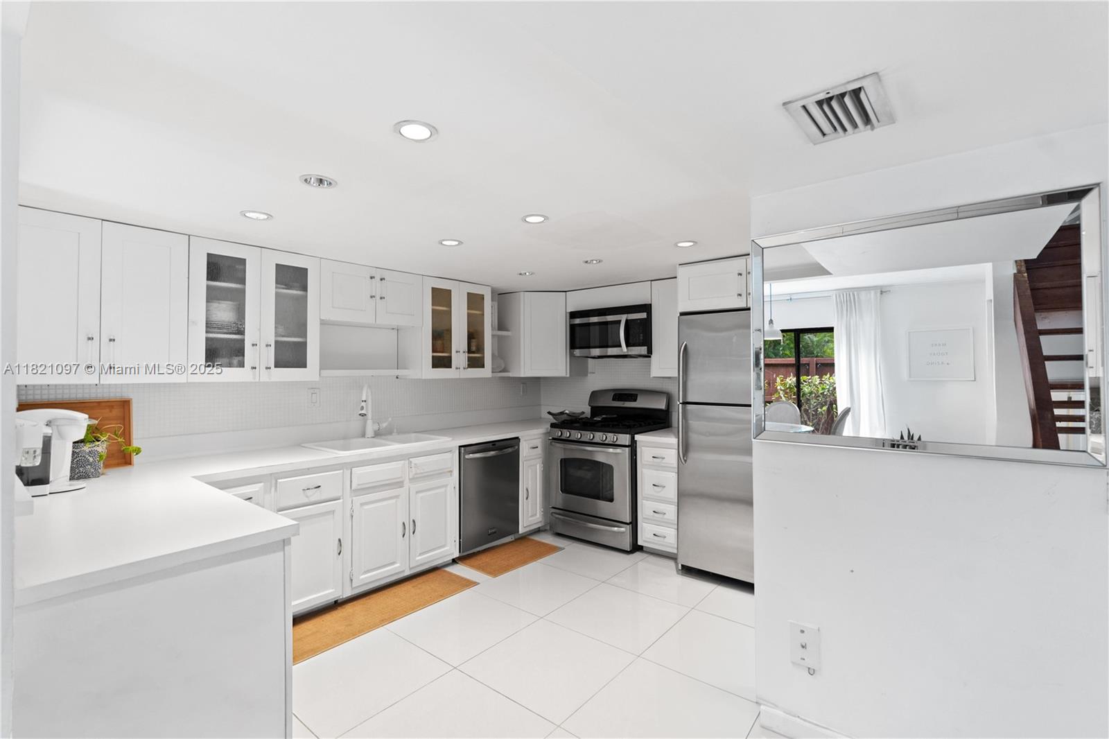 7074 Southwest 114th Place, Unit H Miami, FL 33173 - Photo 13 of 38 a large white kitchen with stainless steel appliances granite countertop a stove and a sink