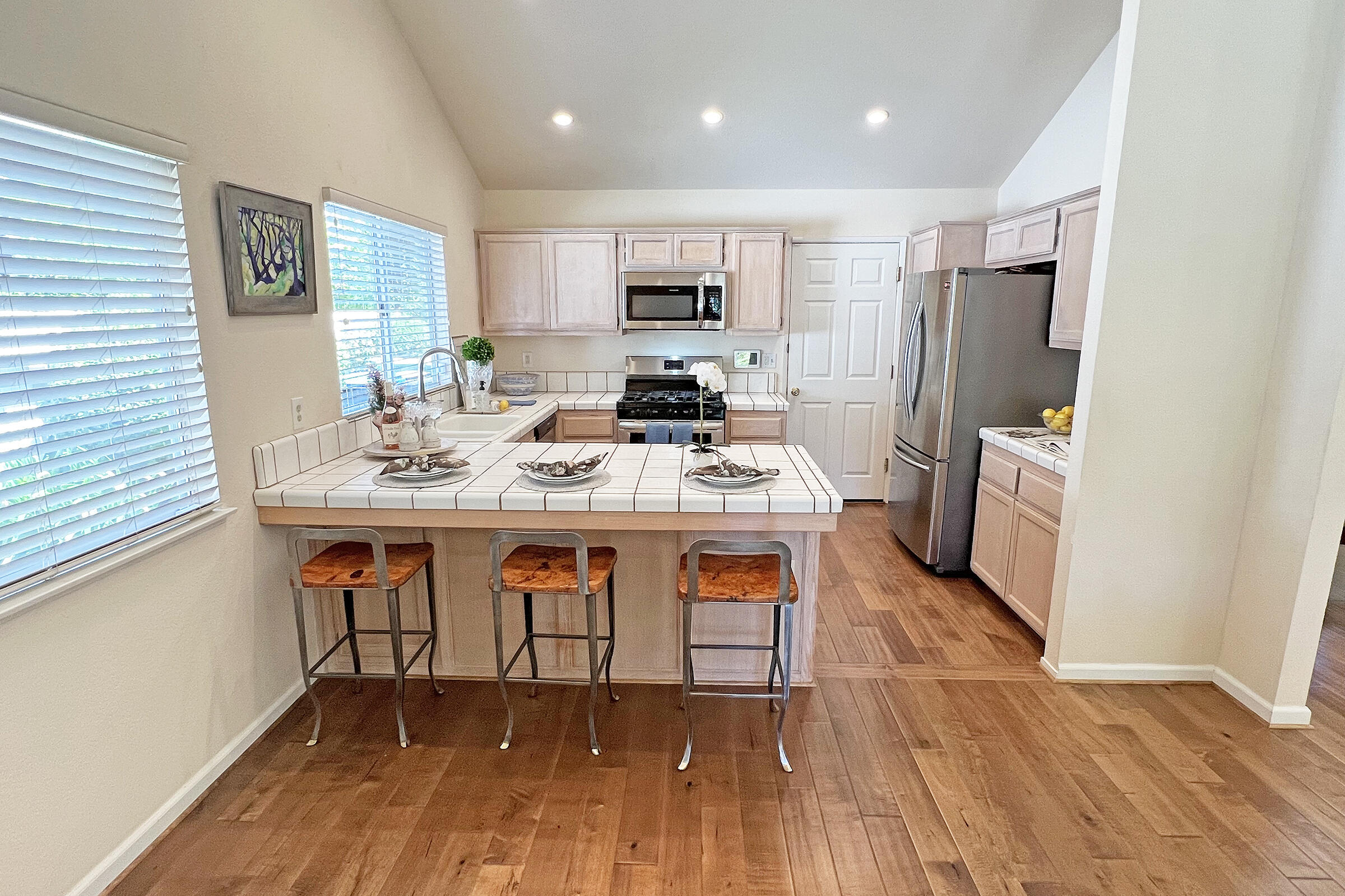 1485 Aarhus Drive Solvang, CA 93463 - Photo 9 of 27 a open kitchen with stainless steel appliances granite countertop a refrigerator a stove top oven a sink dishwasher and white cabinets with wooden floor