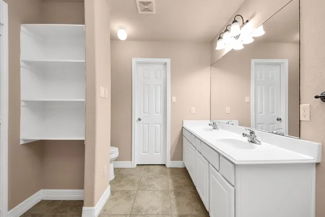 a en suite bathroom with a double vanity sink mirror and