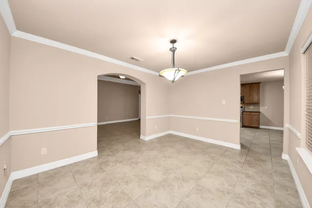 an empty room with closet and a chandelier fan