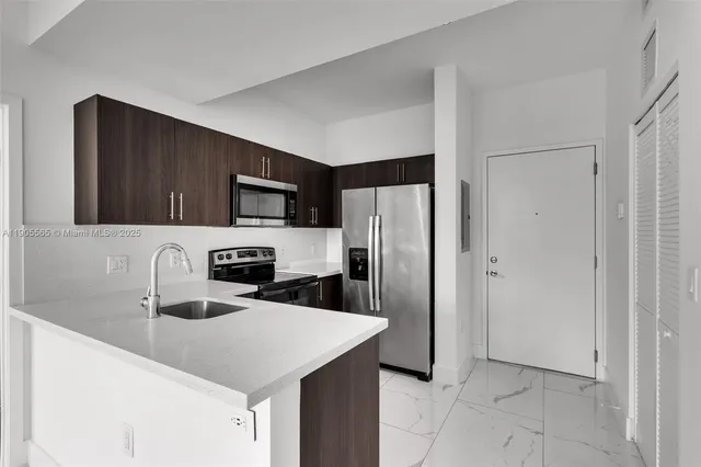 a kitchen with stainless steel appliances a refrigerator sink and microwave