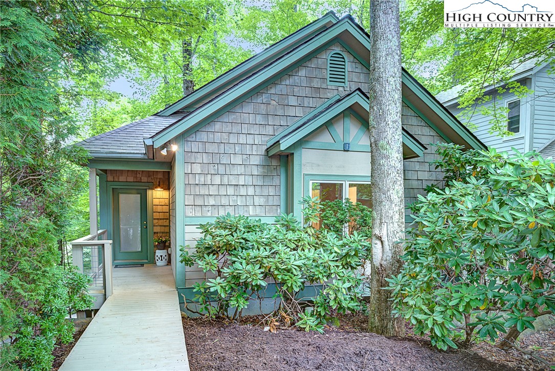 145 Inn At Crestwood Drive Boone, NC 28607 - Photo 1 of 18 a view of brick house with large windows and plants