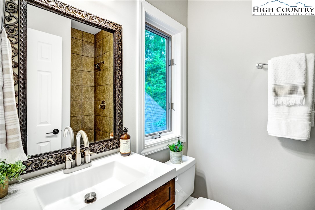 145 Inn At Crestwood Drive Boone, NC 28607 - Photo 14 of 18 a bathroom with a granite countertop sink and a mirror