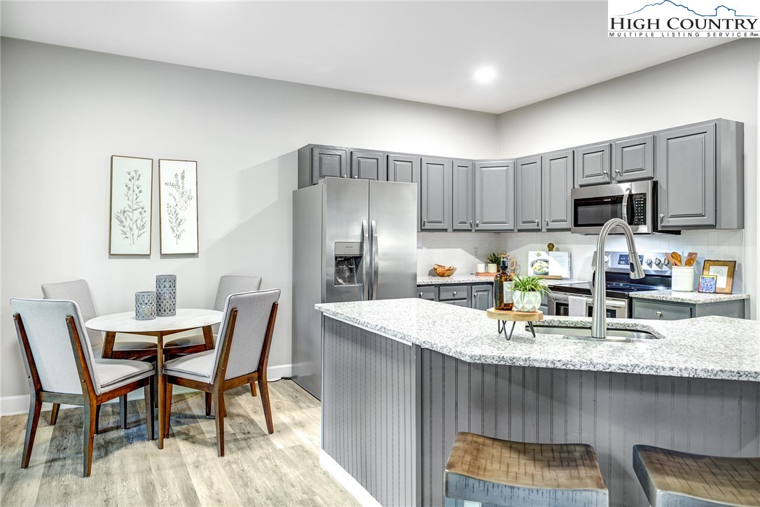 145 Inn At Crestwood Drive Boone, NC 28607 - Photo 6 of 18 a kitchen with kitchen island granite countertop a table chairs microwave and refrigerator