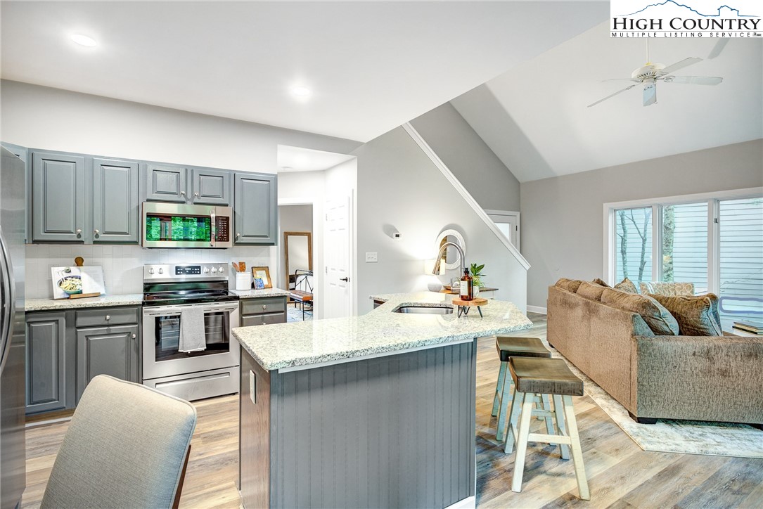 145 Inn At Crestwood Drive Boone, NC 28607 - Photo 7 of 18 a open kitchen with stainless steel appliances granite countertop a stove top oven a sink dishwasher a dining table and chairs with wooden floor