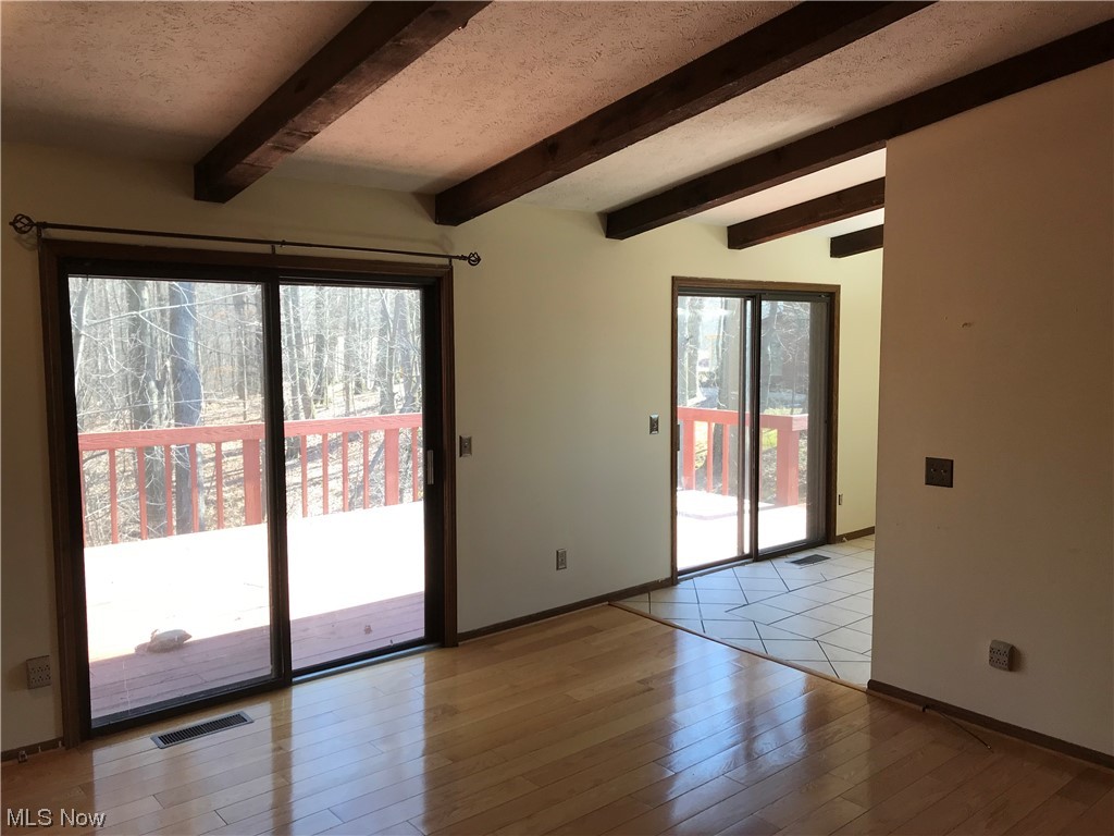 1610 Schroeder Road Mogadore, OH 44260 - Photo 25 of 46 Tiled empty room featuring beam ceiling and a textured ceiling