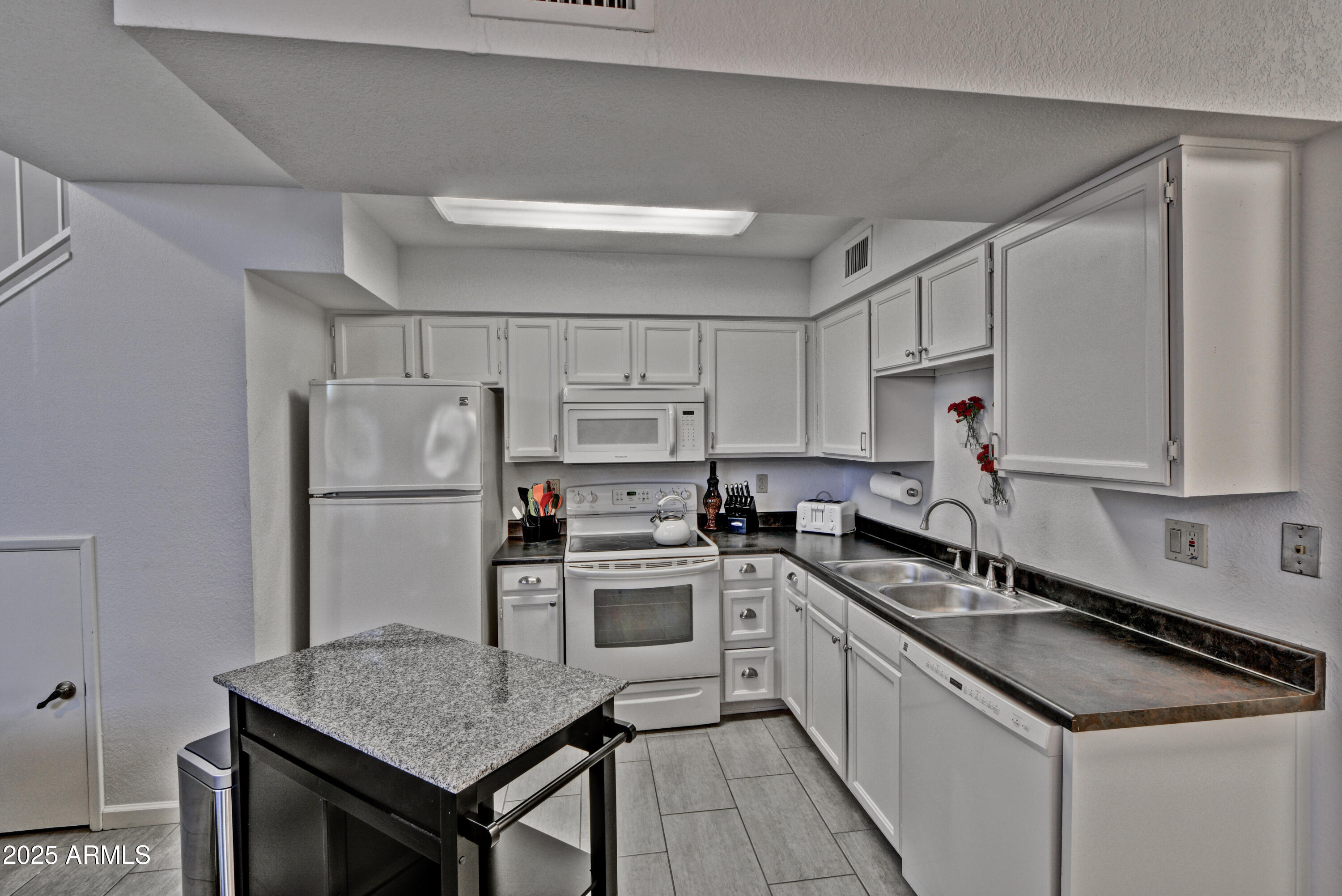 602 North May, Unit 23 Mesa, AZ 85201 - Photo 11 of 25 a kitchen with a sink a stove a refrigerator and cabinets