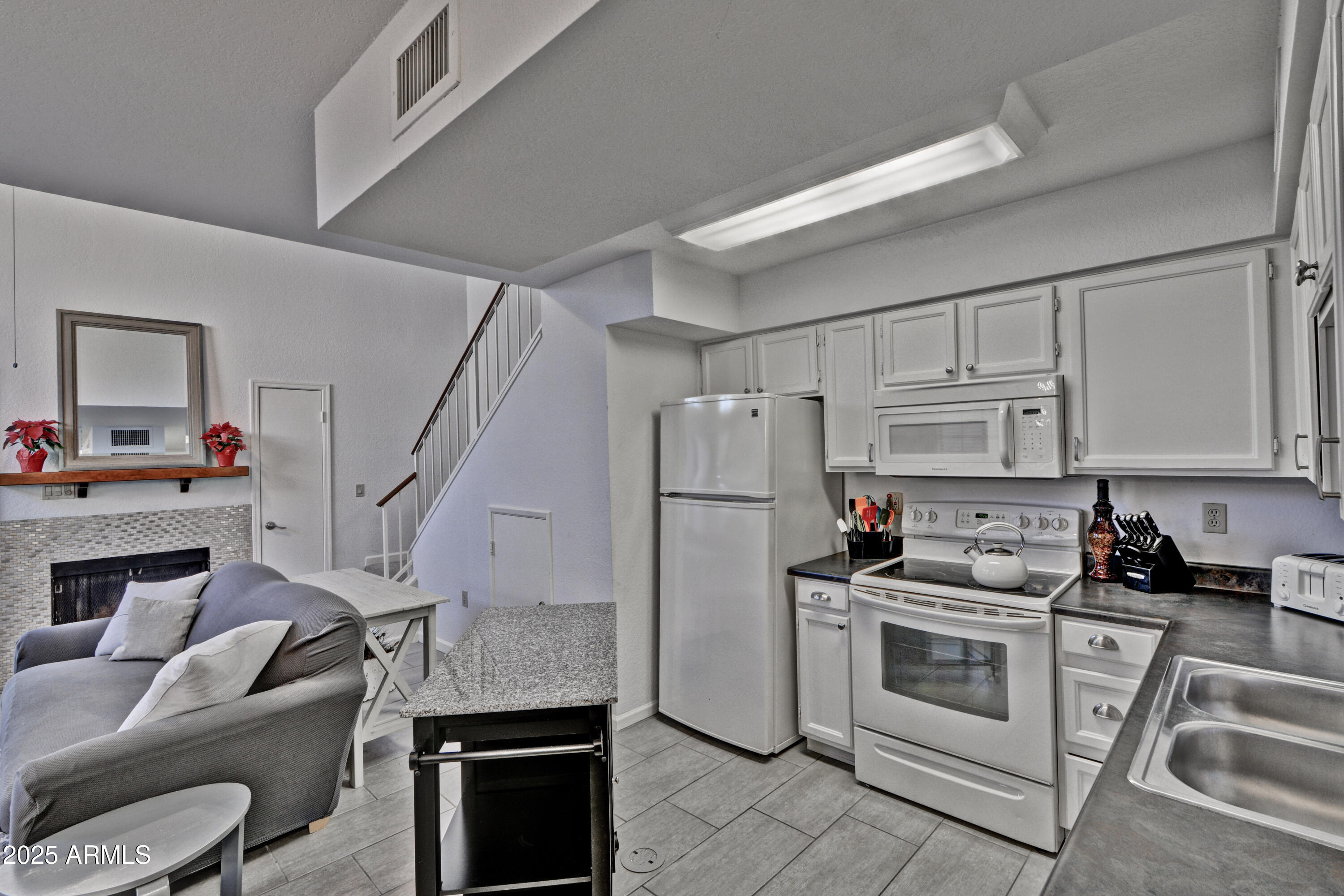 602 North May, Unit 23 Mesa, AZ 85201 - Photo 12 of 25 a kitchen with a refrigerator a stove a microwave and cabinets