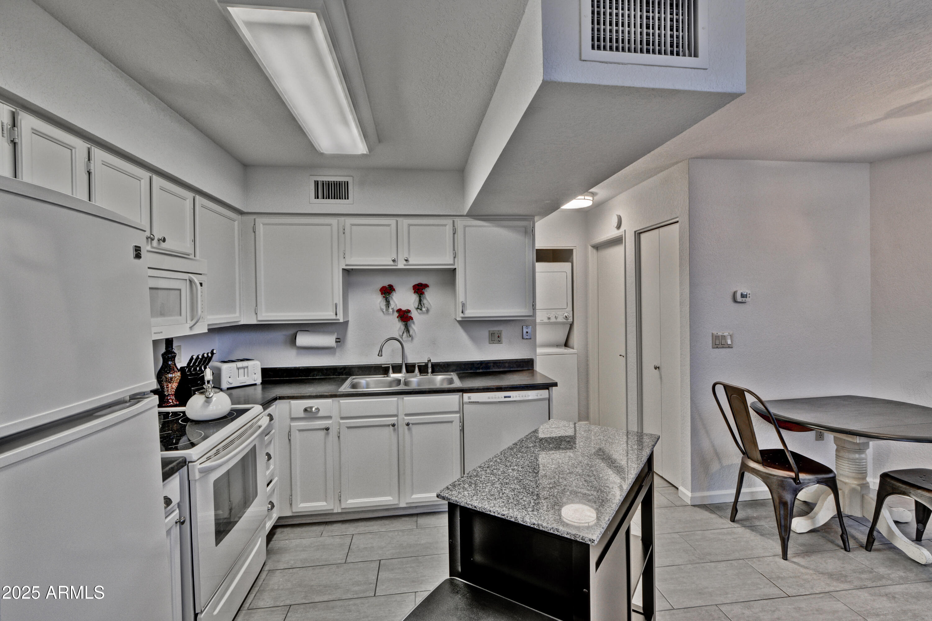 602 North May, Unit 23 Mesa, AZ 85201 - Photo 13 of 25 a kitchen with cabinets and chairs