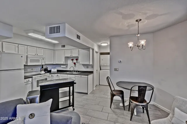 a kitchen with stainless steel appliances granite countertop a sink a stove a refrigerator and island