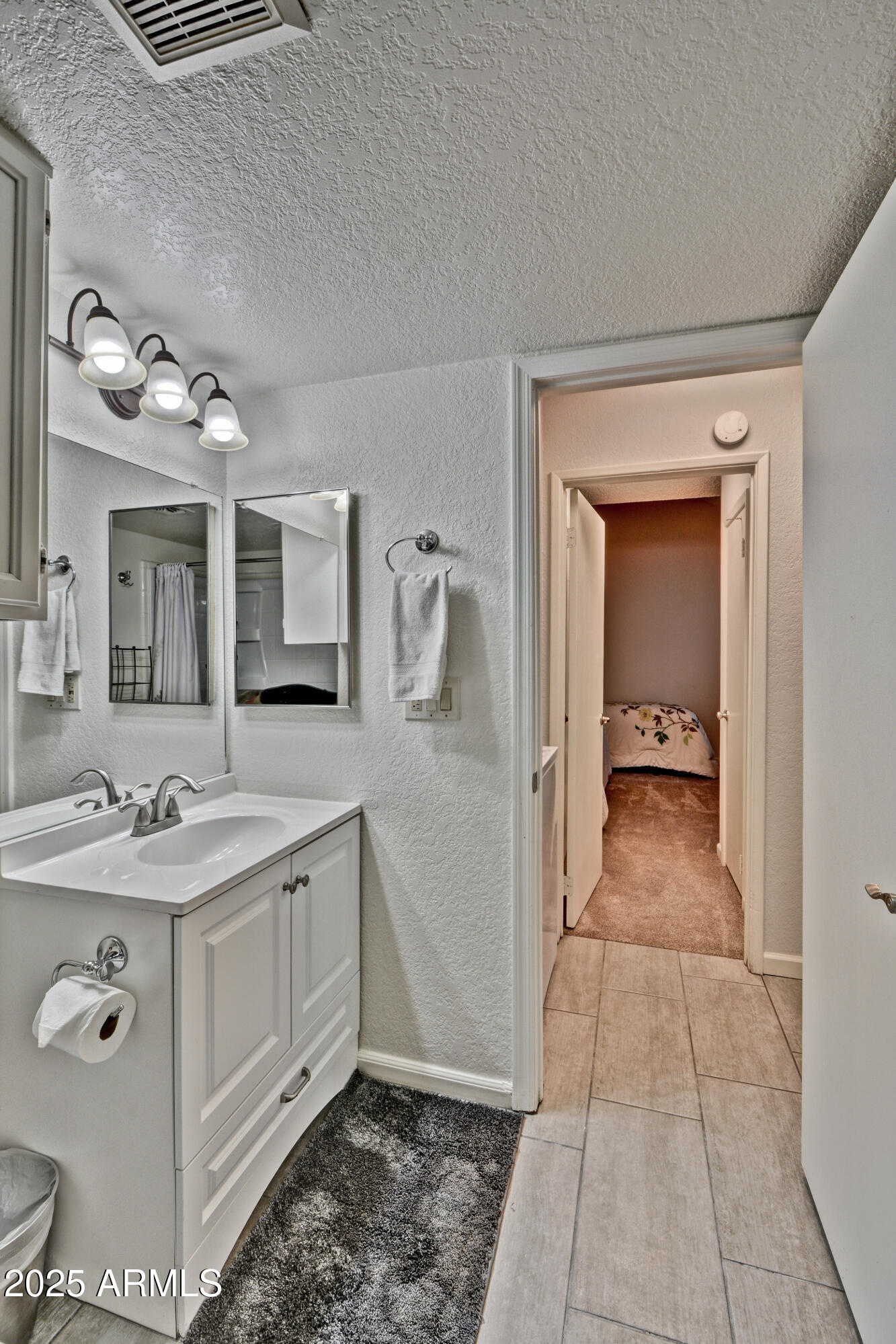 602 North May, Unit 23 Mesa, AZ 85201 - Photo 8 of 25 a bathroom with a sink a toilet and mirror