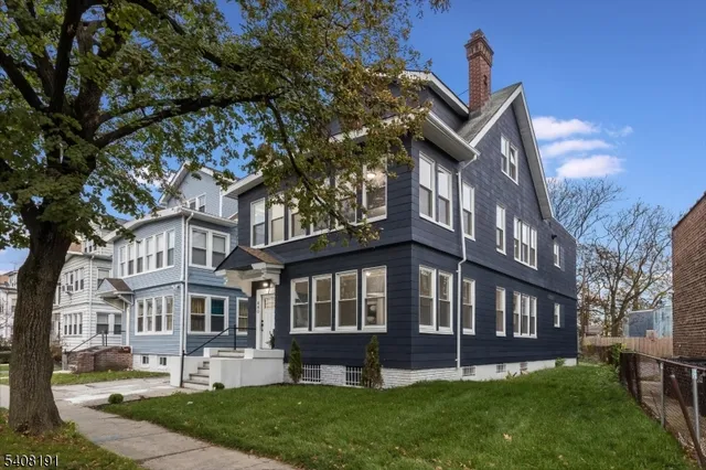 a view of a house with a yard and sitting area
