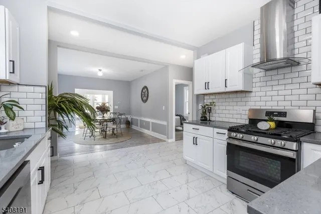 a kitchen with stainless steel appliances a stove a sink a oven a counter space and cabinets