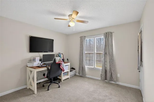 a view of a workspace with furniture and a window