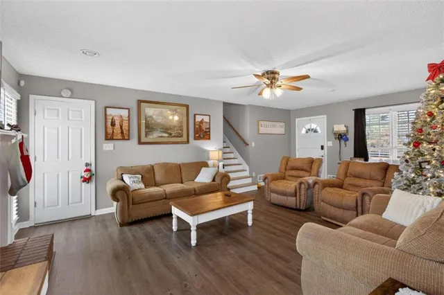 a living room with furniture a ceiling fan and a window