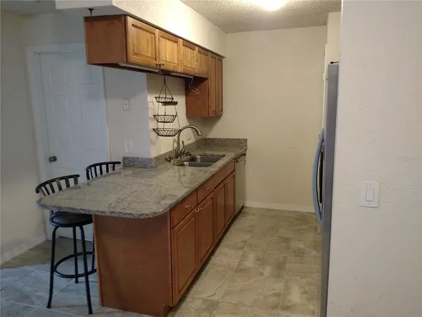 a kitchen with a granite countertop sink a stove and cabinets