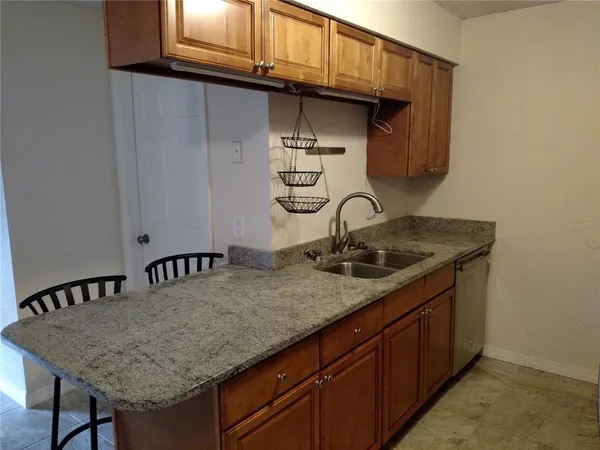a kitchen with a sink a cabinets and wooden floor