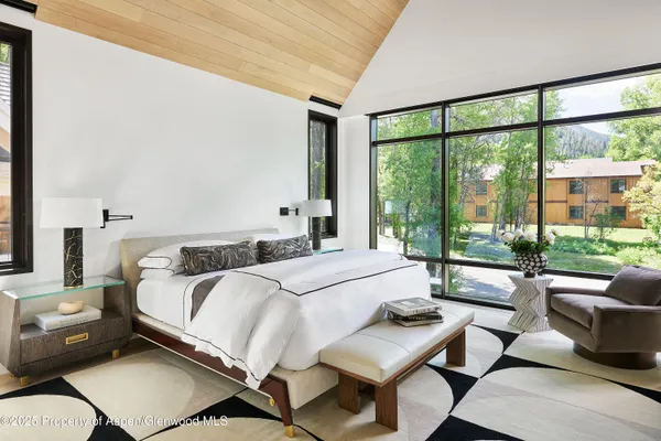 a bedroom with a bed and a large window with balcony view