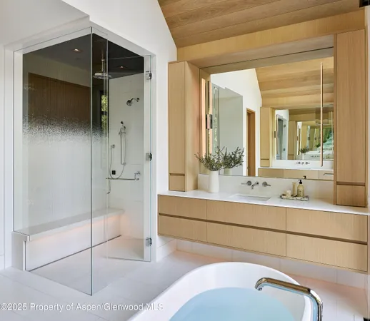 a en suite bathroom with a shower sink and mirror