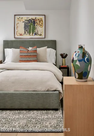 a bedroom with bed and wall painting