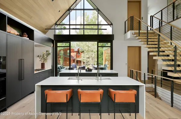 a dining hall with stainless steel appliances granite countertop a stove a sink and a refrigerator