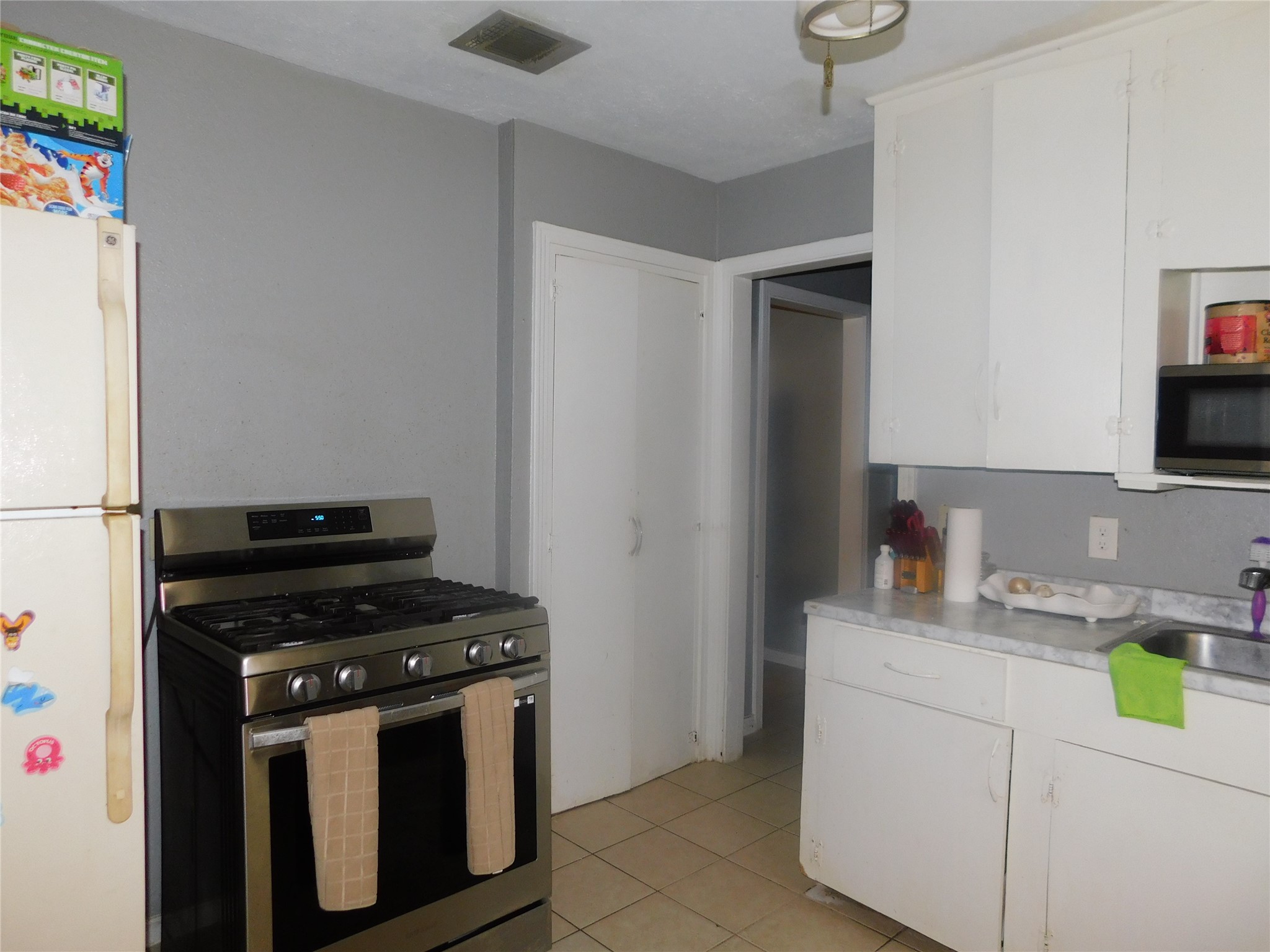 1716 Roxella Street Houston, TX 77093 - Photo 6 of 14 a kitchen with a stove and a refrigerator