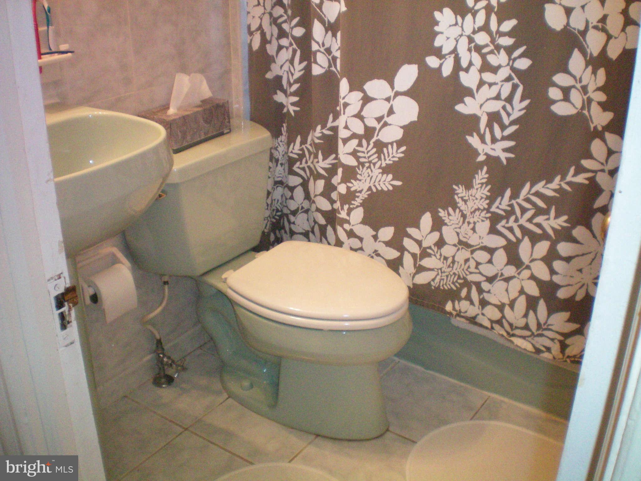 2508 Pinebrush Road Baltimore, MD 21209 - Photo 22 of 30 a white toilet sitting next to a bath tub