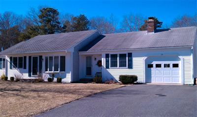 33 James Otis Road Centerville, MA 02632 - Photo 1 of 8 a front view of a house with a yard and garage