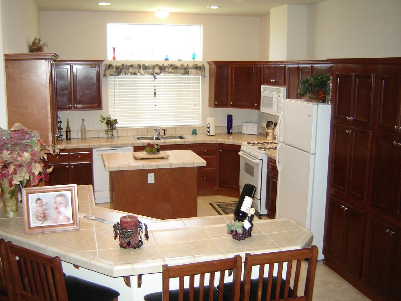 11938 Intermountain Road Redding, CA 96003 - Photo 8 of 14 a kitchen with stainless steel appliances granite countertop a refrigerator a sink dishwasher a stove and white countertops with wooden floor
