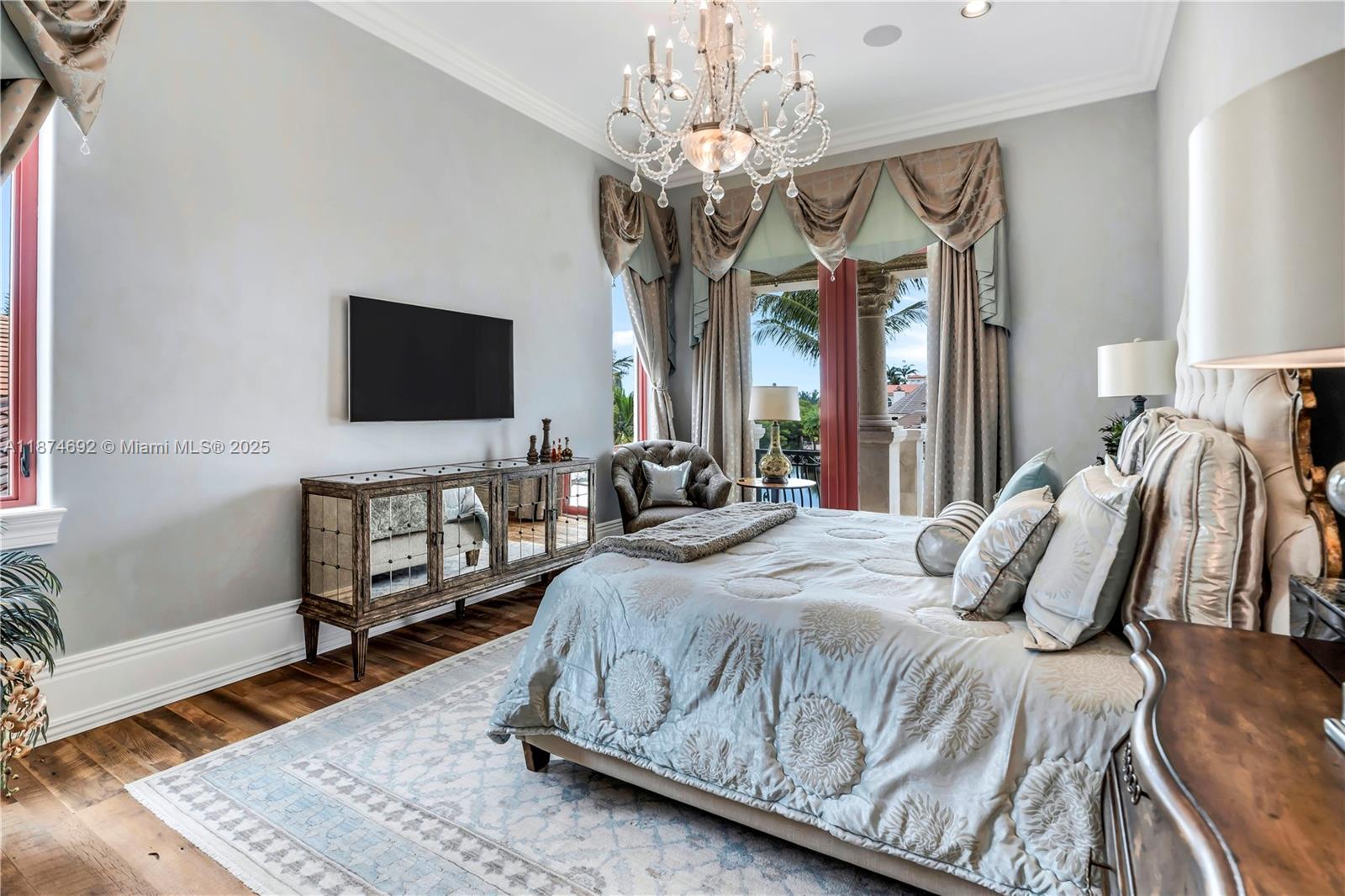 700 47th Street Boca Raton, FL 33431 - Photo 48 of 73 a bedroom with a bed a flat screen tv and a chandelier