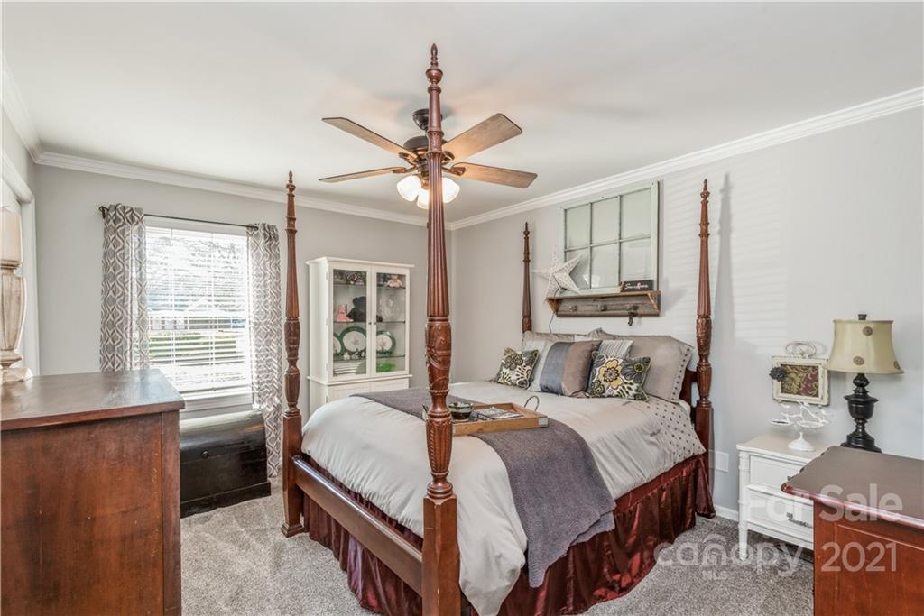 8619 Unity Church Road Denver, NC 28037 - Photo 14 of 24 a bedroom with a large bed and a chandelier