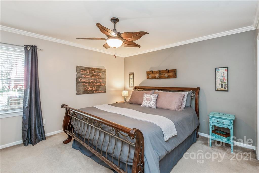 8619 Unity Church Road Denver, NC 28037 - Photo 18 of 24 a bedroom with a bed and a chandelier
