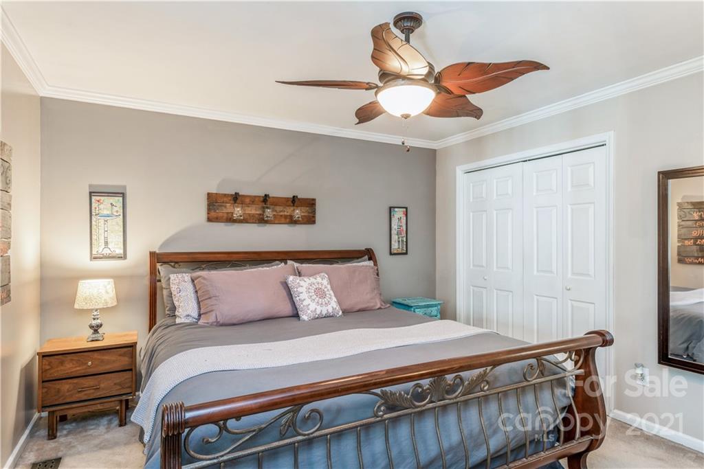 8619 Unity Church Road Denver, NC 28037 - Photo 19 of 24 a bedroom with a bed and a chandelier