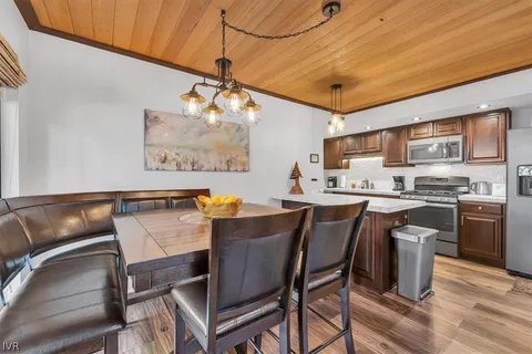 a kitchen with a table chairs refrigerator and microwave