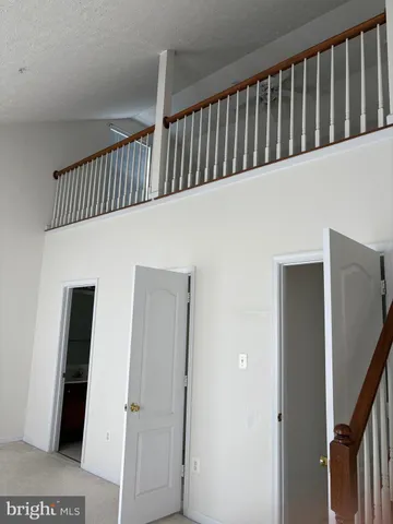 a view of staircase with railing and a hallway